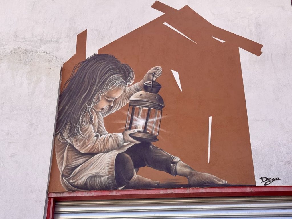 Fresque de street art à Aurec-sur-Loire signée Dege représentant une petite fille tenant une lanterne